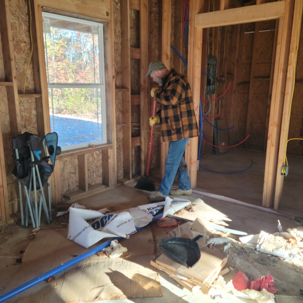 Mike sweeping a pile of construction debris left inside the Cedar Springs retail store